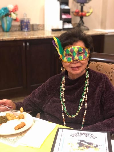 Resident celebrating with festive mask and meal