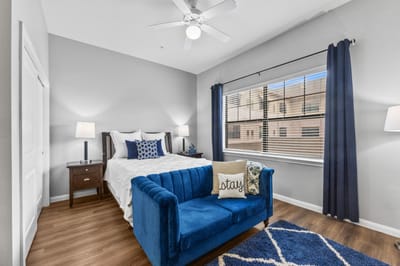 A cozy resident room with a blue couch and bed