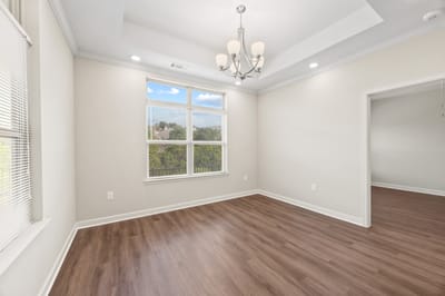 Bright, empty interior room with wood flooring