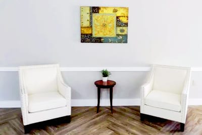 Seating area with two chairs and decorative artwork