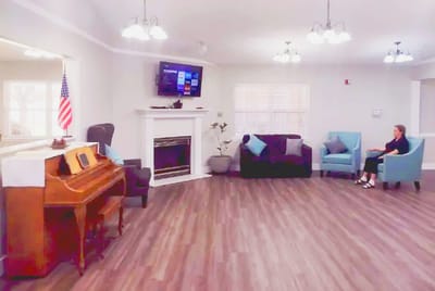 A bright common area with seating and a piano
