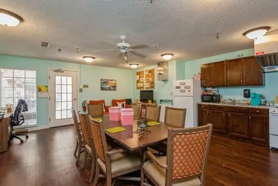 Dining area with tables and kitchen in background