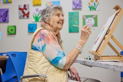 Resident painting in an activity room