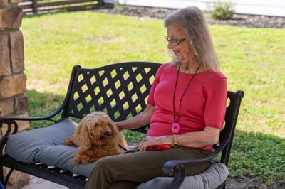 Resident sitting outside with a dog