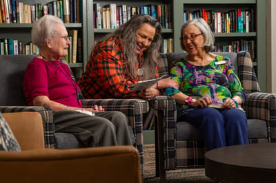 Residents engaging with staff in a cozy common area
