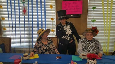 Residents enjoying a themed event with hats and tea