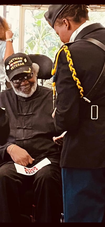 Veteran receiving recognition from staff in a common area