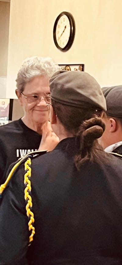 An elderly woman interacting with staff members.