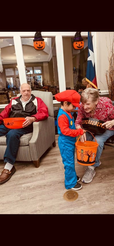 Residents celebrating Halloween with a child in costume
