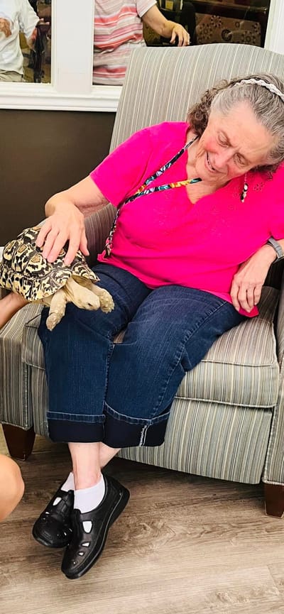 Resident enjoying time with a tortoise indoors