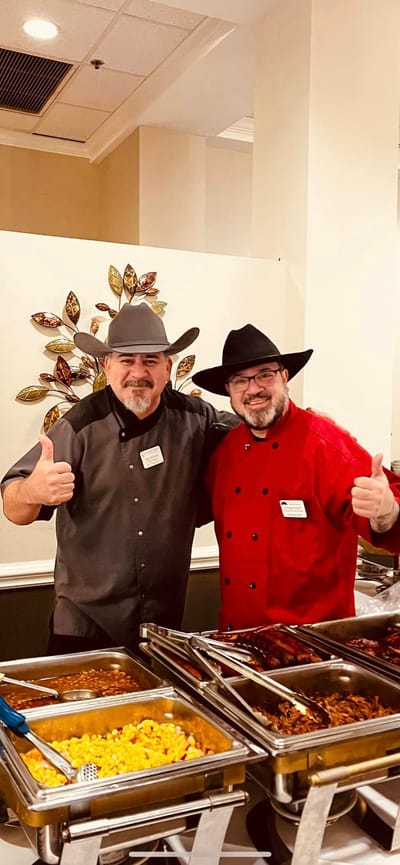 Two staff members smiling in a kitchen setting