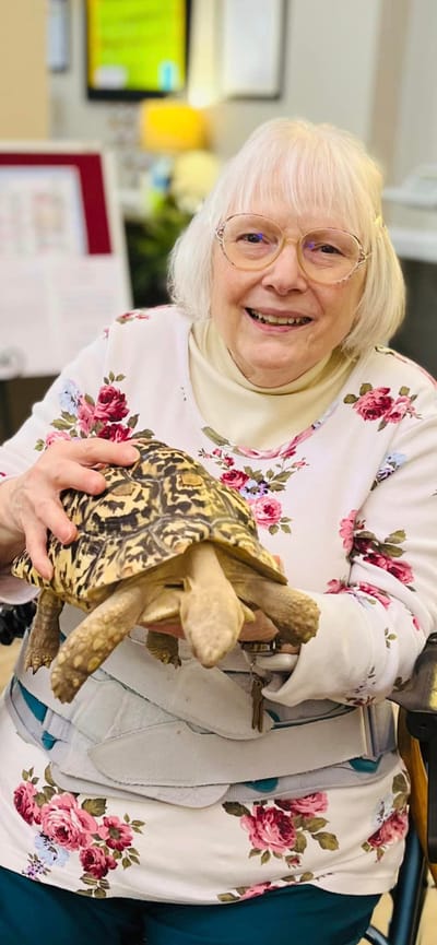 Resident holding a tortoise in a common area