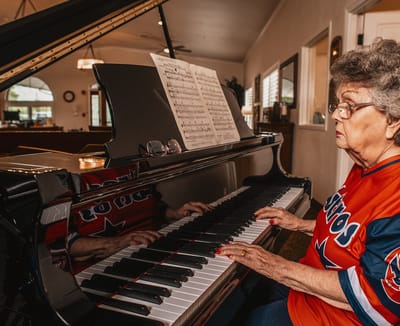 Resident playing piano in a vibrant common area
