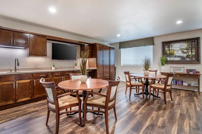 Bright common area with dining tables and kitchen