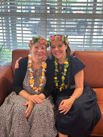 Residents and staff smiling in a festive setting