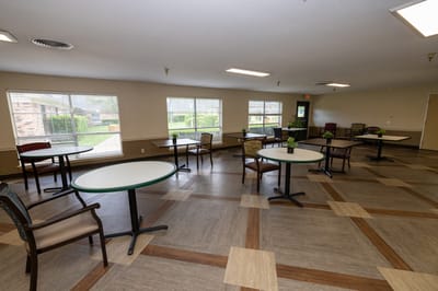 Bright common area with tables and chairs arranged
