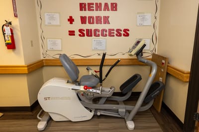 Exercise equipment in a fitness area with motivational signs.