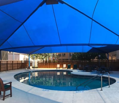 Outdoor pool area with a blue canopy