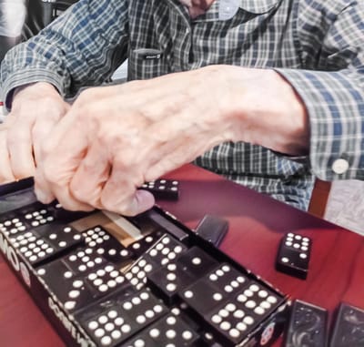 Close-up of a resident's hands playing dominoes