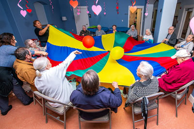 Residents engaging in a colorful group activity with a parachute