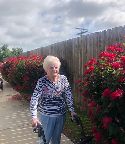 Resident walking in a garden area with flowers