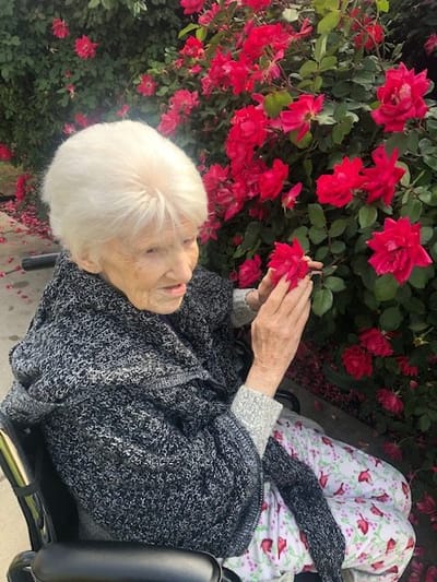 A resident enjoying flowers in a garden
