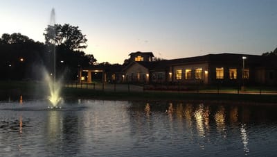 Evening view of a senior living facility near a pond