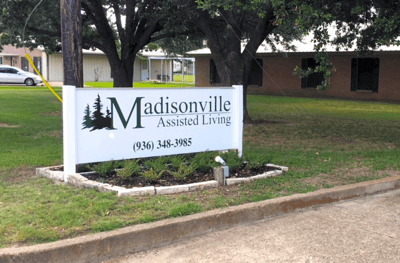 Sign for Madisonville Assisted Living with landscaping