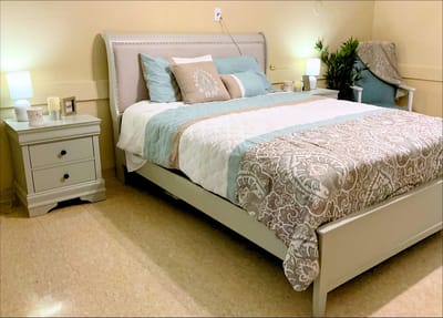 Brightly decorated resident room with a bed and nightstand