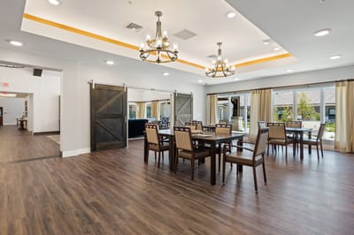 Brightly lit dining area with wooden tables and chairs
