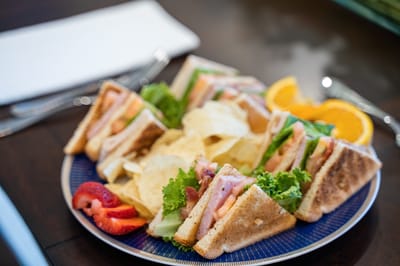 Plate of sandwiches with chips and fruit