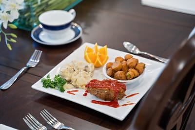 Plated meal with meatloaf, sides, and orange slices