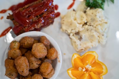 A plate of meatloaf, mashed potatoes, and okra