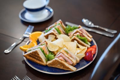 A platter of sandwiches with fruits and chips