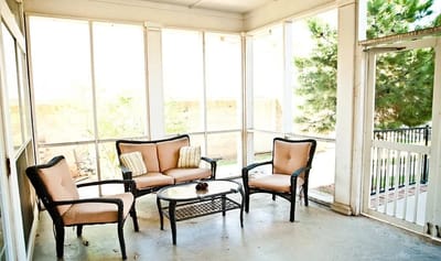 Sunlit sunroom with seating and table