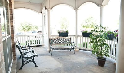 A covered outdoor seating area with benches and plants