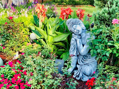 A serene garden with a statue and colorful flowers