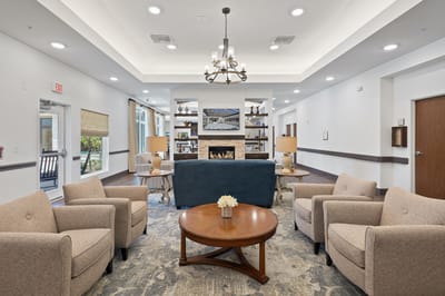 Common area with seating and fireplace in a senior living facility