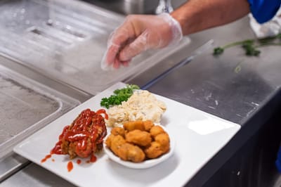 A plated meal with meatloaf, mashed potatoes, and hushpuppies