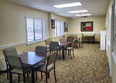Common area with tables and chairs in a well-lit room
