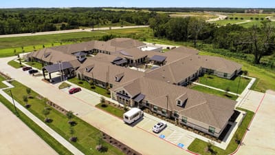 Aerial view of a senior living facility with landscaped grounds