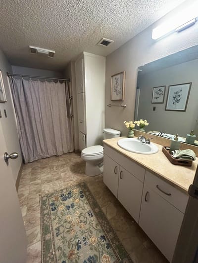 Well-lit bathroom with floral decor and clean amenities