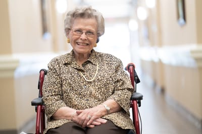 Senior resident smiling in a hallway