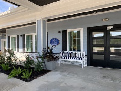 Exterior entrance with facility logo and seating area