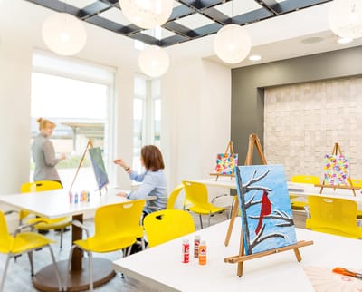 Residents painting in an activity room with art supplies