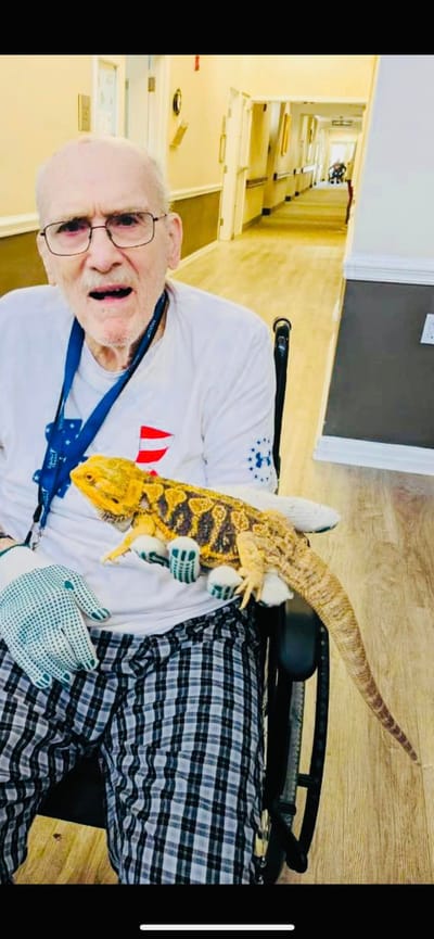 Resident holding a lizard in a hallway