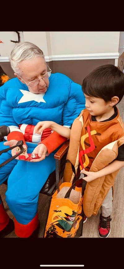 A resident in costume interacting with a child in costume