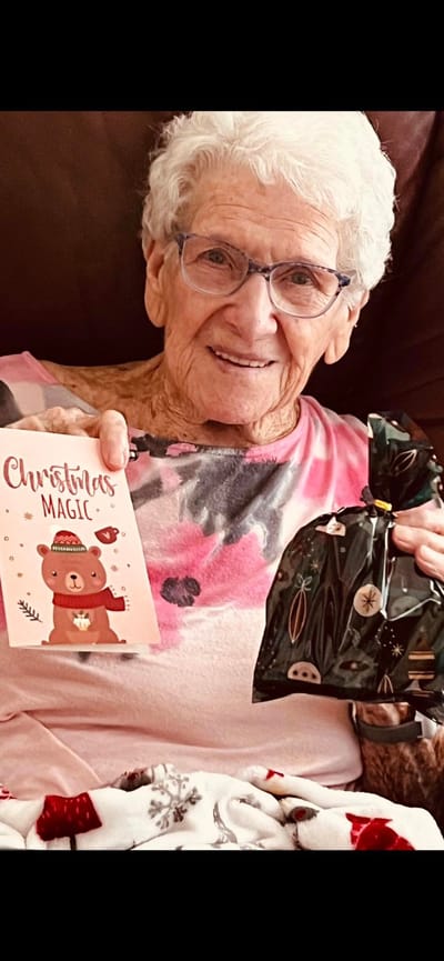 Resident holding a Christmas card and gift