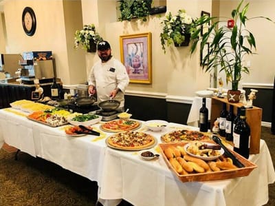 A catered dining service with a chef and food spread