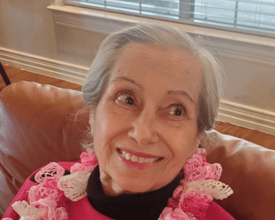 Senior resident smiling, wearing a floral scarf